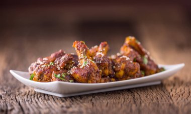 Tavuk kanadı. Kızarmış tavuk kanatları beyaz kase sarımsak sosu ketçap ve patates kızartması