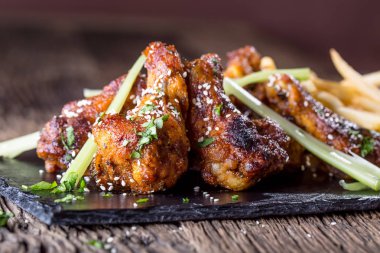 Tavuk kanadı. Kızarmış tavuk kanatları beyaz kase sarımsak sosu ketçap ve patates kızartması