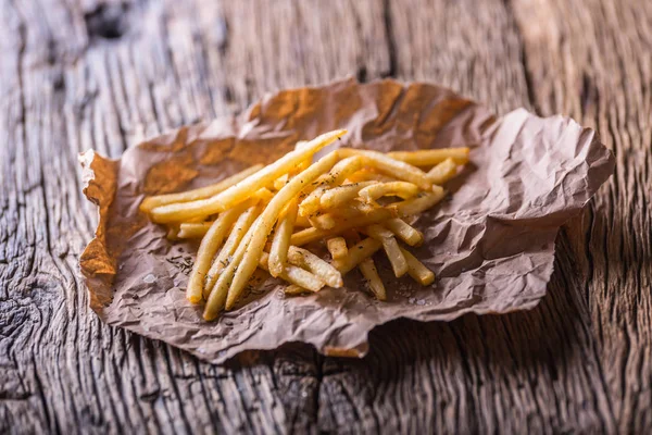 Patatas fritas. Patatas fritas doradas con sal y hierbas secas sobre tabla de madera — Foto de Stock