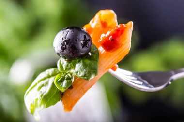Makarna Penne domates Bolognese sos, Parmesan peyniri Siyah Zeytin ve fesleğen bir çatal üzerinde. Akdeniz yemekleri. İtalyan mutfağı