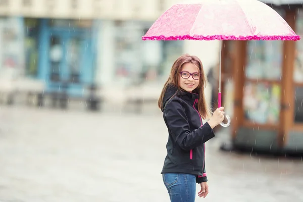 Ritratto di felice bella giovane ragazza pre-adolescente con ombrello rosa sotto la pioggia — Foto Stock