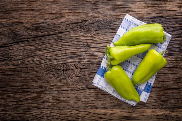 Green peper.Fresh green pepper blue checkered tablecloth on old oak table — Stock Photo, Image