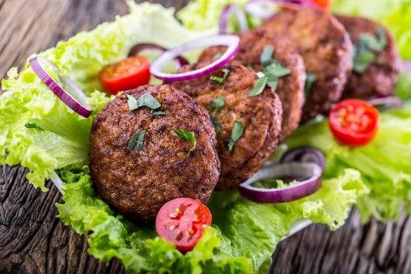 Beef Burgers meatballs cutlets with lettuce salad tomato onion on wooden board — Stock Photo, Image