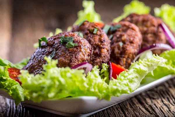 Beef Burgers meatballs cutlets with lettuce salad tomato onion on wooden board — Stock Photo, Image