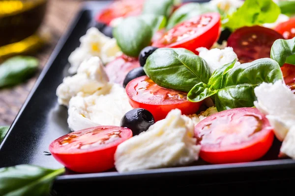 Sałatka Caprese Salad.Mediterranean. Mozzarella pomidorkami bazylii i oliwy z oliwek na stary dębowy stół. Dania kuchni włoskiej — Zdjęcie stockowe