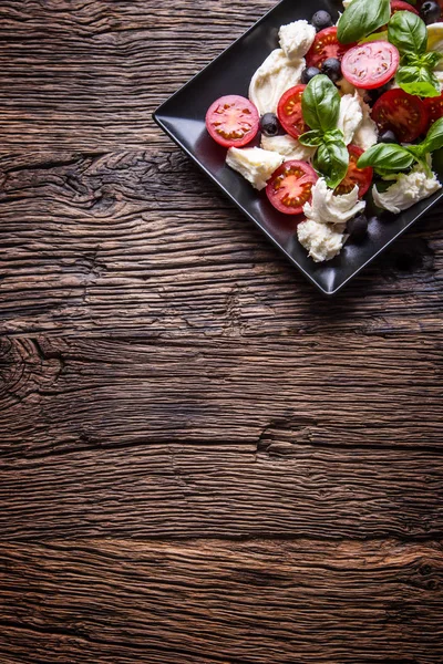 凯普莱斯 Salad.Mediterranean 沙拉。马苏里拉樱桃番茄罗勒和旧橡木桌子上橄榄油。意大利菜 — 图库照片