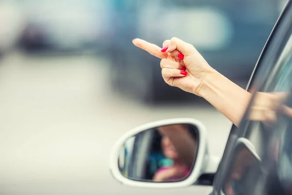 Attraktive Frau zeigt obszöne Geste aus dem Auto — Stockfoto