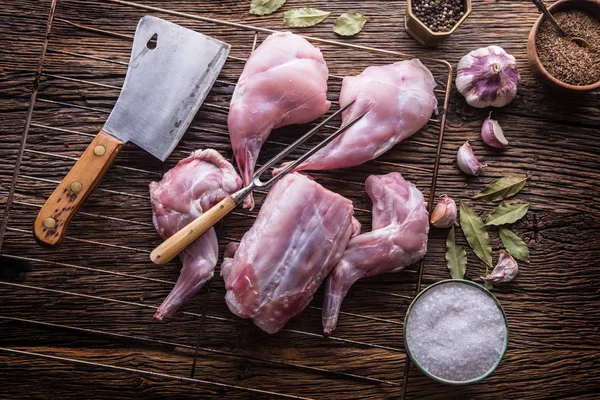 Lapin. Tranches de lapin cru avec des épices ustensile de cuisine à l'ail, fourchette et boucher. Cuisine de chasse — Photo