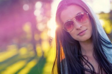 Yaz gündoğumu, güneş gözlüklü modern genç kadın portresi