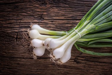 Soğan. Rustik meşe masada genç taze soğan