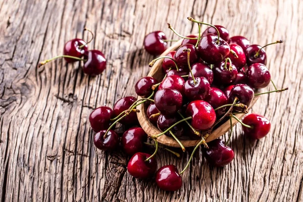 Cherries. Fresh sweet cherries. Delicious cherries with water drops in retro bowl on old oak table