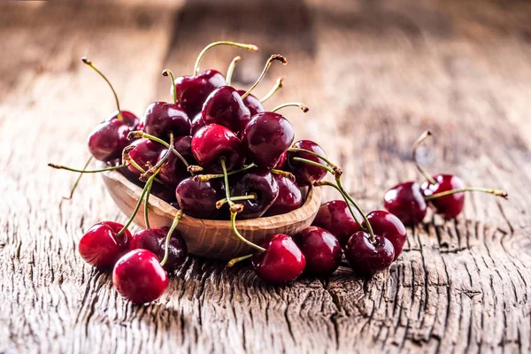 Cherries. Fresh sweet cherries. Delicious cherries with water drops in retro bowl on old oak table