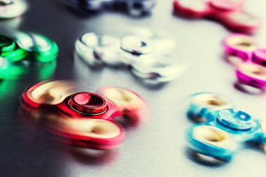 Spinner kıpır. Birkaç renkli bir paslanmaz çelik plaka üzerinde spinners kıpır