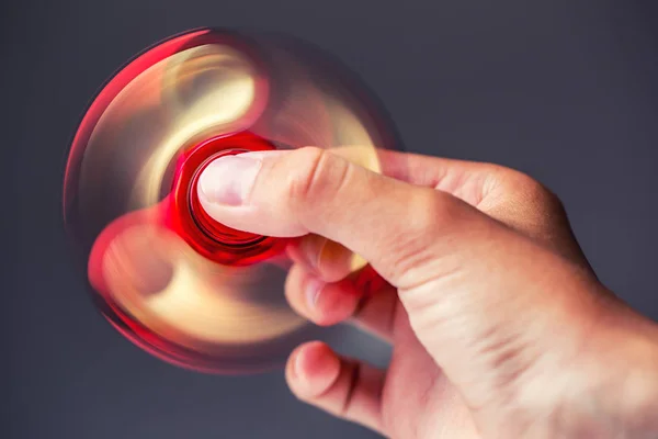 Fidget Spinner.Red sfidget pinner em uma mão de menina — Fotografia de Stock