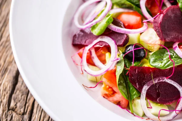 Salade de légumes. Assiette de salade aux légumes sur table en chêne rustique. Assortiment d'ingrédients de la salade de légumes — Photo