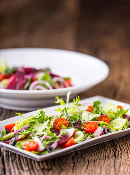 Salade de légumes. Assiette de salade aux légumes sur table en chêne rustique. Assortiment d'ingrédients de la salade de légumes — Photo