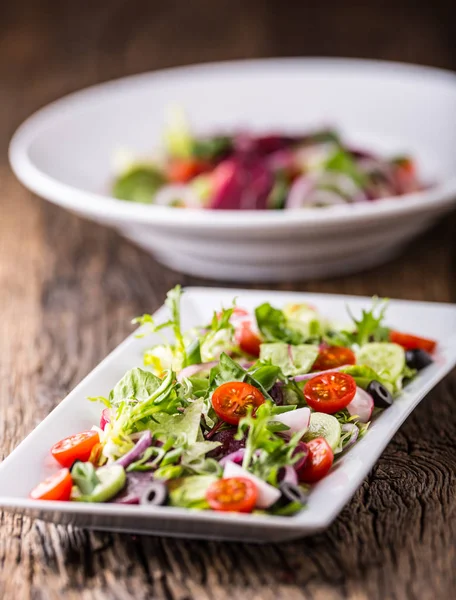 Grönsakssallad. Tallrik med sallad med grönsaker på rustika ekbordet. Sortiment av ingredienser av grönsakssallad — Stockfoto