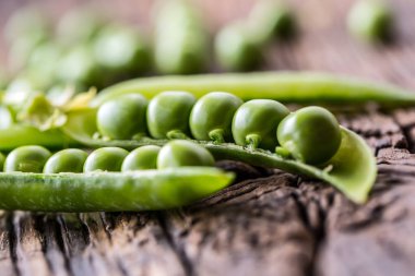 Bezelye. Ev yapımı taze biyo bezelye ve bakla eski meşe tahtası üzerinde. Sağlıklı taze yeşil sebze - bezelye ve bakla