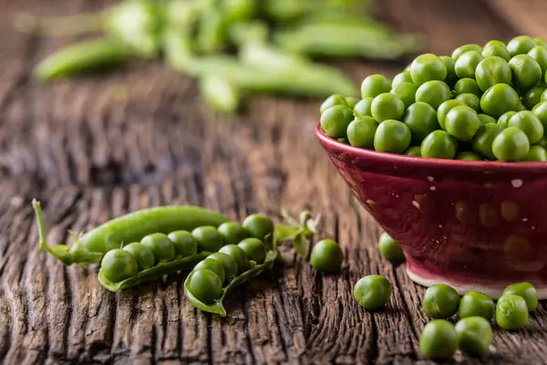 Des petits pois. Pois et gousses bio frais faits maison sur vieux carton de chêne. Légumes verts frais sains - pois et gousses — Photo