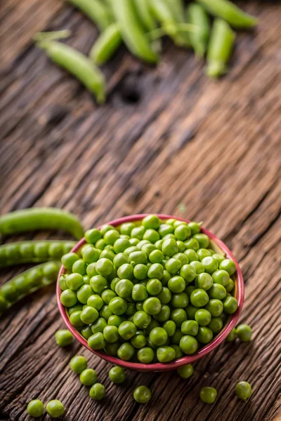 Guisantes. Guisantes y vainas frescas bio caseras sobre tabla de roble viejo. Vegetales verdes frescos saludables - guisantes y vainas — Foto de Stock