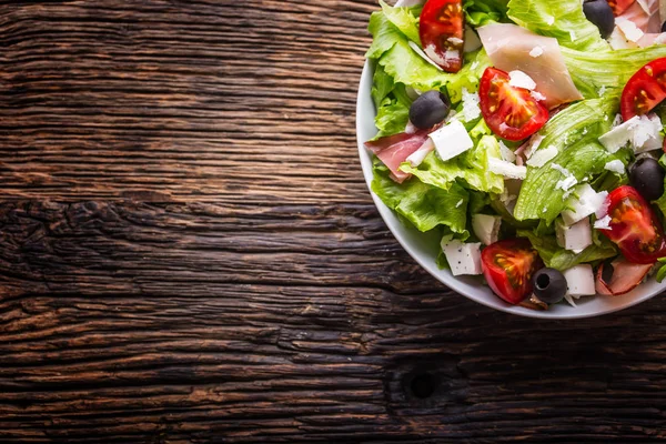 Salada. Salada de alface fresca de verão.Salada mediterrânea saudável azeitonas tomates queijo parmesão e presunto — Fotografia de Stock