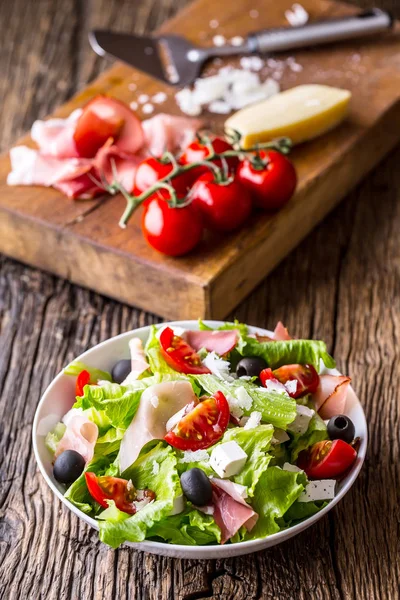 Sałatka. Letnia Sałatka sałata. Zdrowe sałatki śródziemnomorskiej oliwki pomidory ser parmezan i szynki — Zdjęcie stockowe