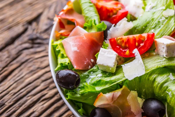 Insalata. Insalata estiva di lattuga fresca. Insalata mediterranea sana olive pomodori parmigiano e prosciutto — Foto Stock