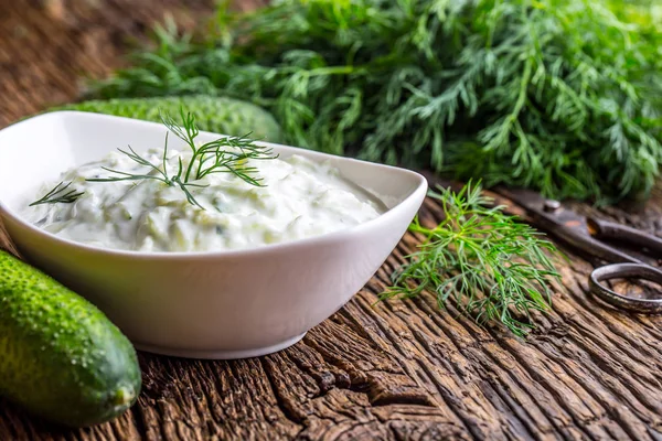 Tzatziki. Salsa griega tradicional o aderezo tzatziki preparado con aceite de oliva yogur crema agria pepino rallado y eneldo fresco. Cocina mediterránea —  Fotos de Stock