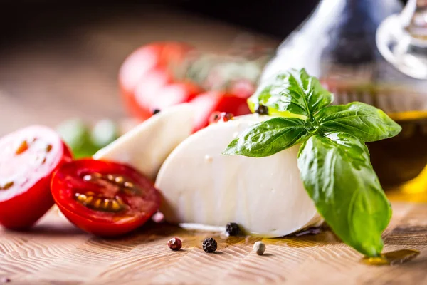 Liście bazylii, pomidor, mozzarella i oliwy z oliwek. Składniki na włoski Sałatka caprese — Zdjęcie stockowe