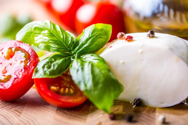 Liście bazylii, pomidor, mozzarella i oliwy z oliwek. Składniki na włoski Sałatka caprese — Zdjęcie stockowe