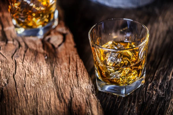 Whiskey-Drink. Whiskey-Drinks auf rustikalem Eichenholz mit Eiswürfeln — Stockfoto