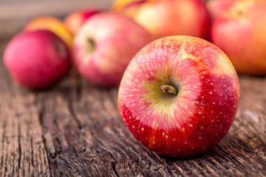 Elma. Diğer pozisyonlarda ahşap tahta üzerinde kırmızı elma