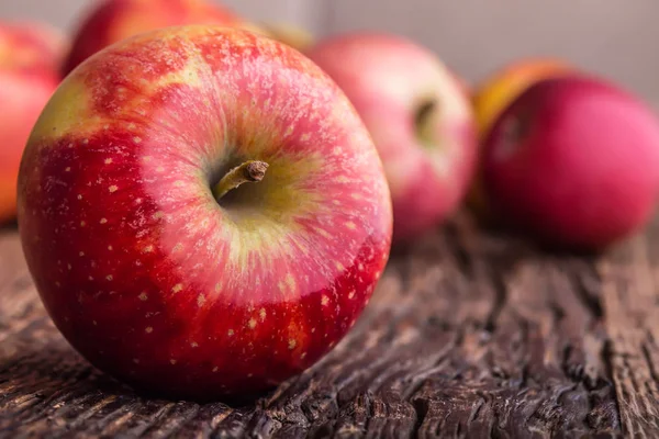 Elma. Diğer pozisyonlarda ahşap tahta üzerinde kırmızı elma