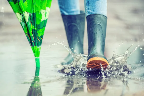 Дівчина в гумових чоботях на відкритому повітрі в дощовий день — стокове фото