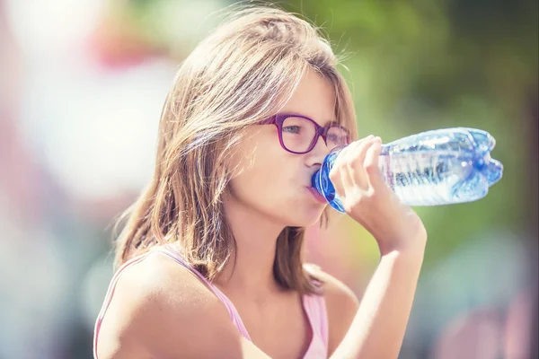 Молодая девушка пьет свежую воду в жаркий летний день — стоковое фото