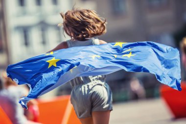AB bayrağı. Avrupa Birliği bayrağı ile şirin mutlu kız. Kentin Avrupa Birliği bayrağı sallayarak genç genç kız