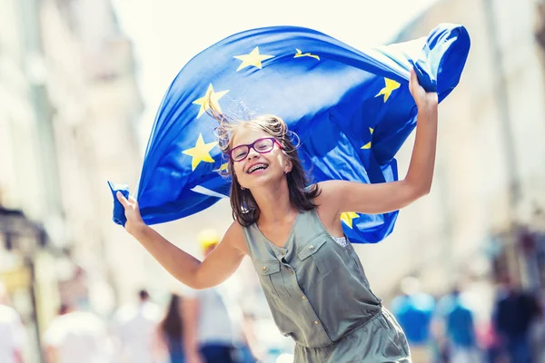 Vlajka EU. Roztomilý šťastná dívka s vlajkou Evropské unie. Mladá dospívající dívka mávat s vlajkou Evropské unie ve městě — Stock fotografie