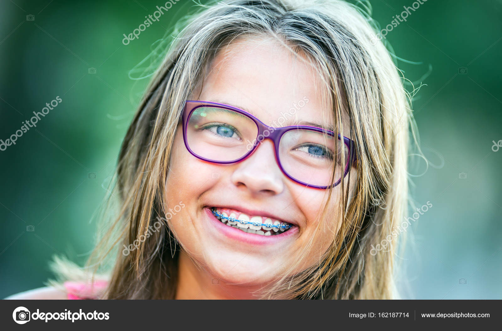 Happy smiling girl with dental braces and glasses. Young cute caucasian