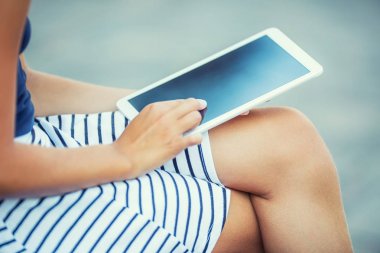 Elinde bir tablet ile oturan genç çekici kız