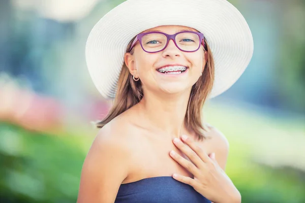 Szczęśliwy uśmiechający się dziewczyna z aparatów na zęby i okulary. Młodych cute blond dziewczynka kaukaski sobie szelki zęby i okulary — Zdjęcie stockowe