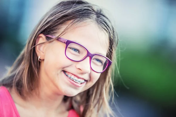 Menina sorridente feliz com aparelho dental e óculos. Jovem bonito caucasiano menina loira vestindo dentes aparelhos e óculos — Fotografia de Stock