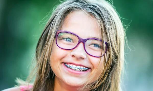 Happy smiling girl with dental braces and glasses. Young cute caucasian blond girl wearing teeth braces and glasses — Stock Photo, Image