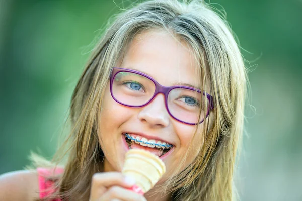 Lyckligt leende flicka med tandställning och glasögon. Ung söt kaukasiska blond flicka klädd tänder hängslen och glasögon — Stockfoto