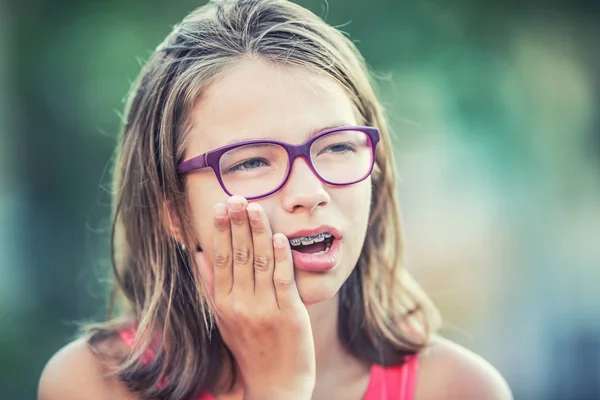 Porträtt av ung tonåring flicka med tandvärk. Flicka med tandställning och glasögon — Stockfoto