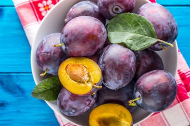 Erik. Tahtası ahşap veya beton bir kapta taze sulu Erik