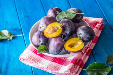 Erik. Tahtası ahşap veya beton bir kapta taze sulu Erik