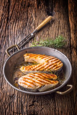 Somon balığı. Izgara balık somon. Rusticc ahşap masa üzerinde kızarmış tavada Somon ızgara biftek