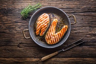 Somon balığı. Izgara balık somon. Rusticc ahşap masa üzerinde kızarmış tavada Somon ızgara biftek