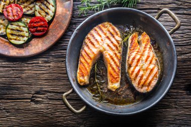 Somon balığı. Izgara balık somon. Rusticc ahşap masa üzerinde kızarmış tavada Somon ızgara biftek