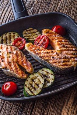 Somon balığı. Izgara balık somon. Rustik ahşap masa üzerinde ızgara tava içinde ızgara somon steak